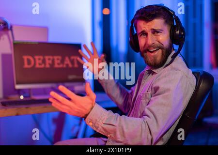 Frustrated gamer reacts to defeat in neon light Stock Photo
