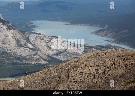 Hikers scale the ridge of Roche Miette in Jasper National Park.  Brule Lake lays in the background looking north towards Hinton. Stock Photo