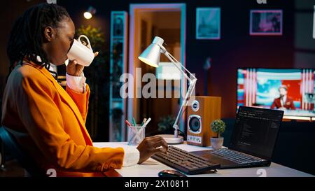 African american IT student practicing coding or programming exercises, learning hardware language and system debugging. Young woman studying database script on html window. Camera B. Stock Photo