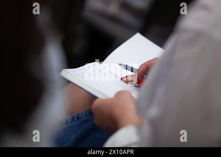 Woman taking notes in a notepad. Close-up. Selective focus. Stock Photo