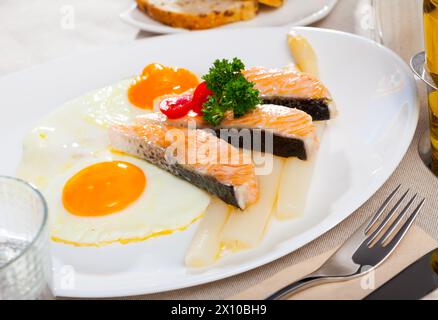 Fried salmon with scrambled eggs and asparagus Stock Photo