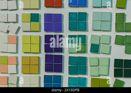 Dozens of small ceramic tiles of various colors are arranged on a white background Stock Photo