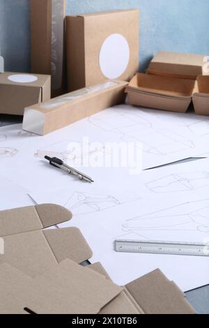 Creating packaging design. Drawings, boxes and stationery on table ...
