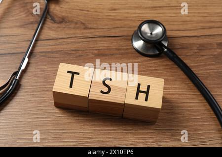 Endocrinology. Stethoscope and cubes with thyroid hormones on wooden table Stock Photo