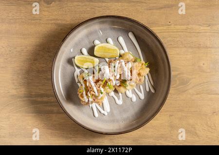 a plate of spanish tapa calamari andaluz fried on a nice dish with lime wedges deliciously garnished Stock Photo