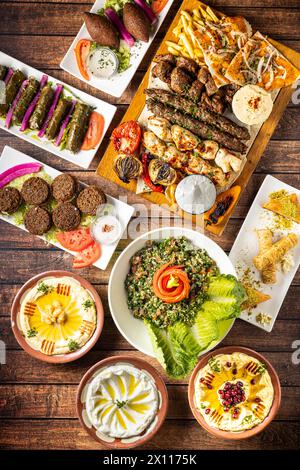 mediterranean arab dishes from top view on a wood table tabouleh, kibbeh, humus, grape leaves stuffed with rice, Stock Photo