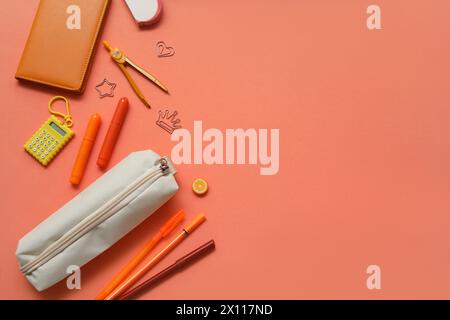 Beige pencil case with different school stationery and notebooks on orange background Stock Photo