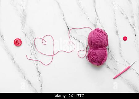 Yarn ball, crochet hook and buttons on white grunge background Stock Photo