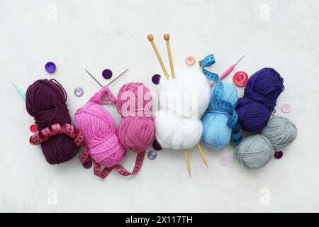 Yarn balls, knitting needles and buttons on white background Stock Photo