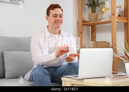 Young man with hearing aid video chatting at home Stock Photo