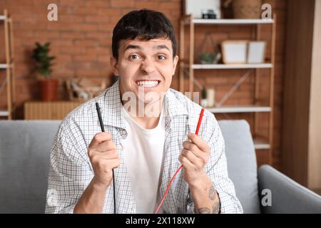 Electrocuted young man with wires at home, closeup Stock Photo