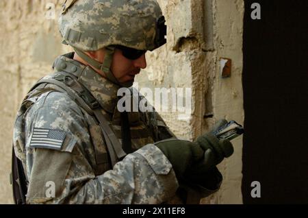 1st Lt. Dan Pitchford, an explosive ordnance disposal platoon leader with 47th Ordnance Company, 79th Ordnance Battalion, Task Force Troy from Dassel, Minn., prepares C-4 explosive to demolish an abandoned building in southern Baghdad. The building was demolished to clear room for a range to be used to train Iraqi National Police ca. 2004 Stock Photo
