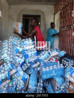 Haitians assist Marines and sailors with Combat Logistics Battalion 22, 22nd Marine Expeditionary Unit, stack cases of water at a non-governmental distribution site in Petit Goave, Haiti, Jan. 31, 2010. Marines and sailors of CLB-22 conducted such missions throughout the area since their arrival in Petit Goave almost two weeks earlier. Stock Photo