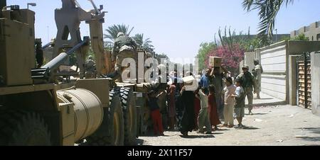 After several days of fighting in eastern Baghdad, Soldiers from 2nd Battalion, 8th Cavalry Regiment of the 1st Cavalry Division hand out humanitarian aid rations to the people of Sadr City ca. July 26, 2004 Stock Photo