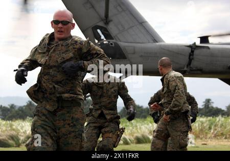 Marines from Lima Company, Battalion Landing Team, 3rd Battalion, 2nd Marine Regiment, 22nd Marine Expeditionary Unit, move away from a CH-53E Super Stallion with Marine Heavy Helicopter Squadron 461 (Reinforced), 22nd MEU, as it prepares to depart from a landing zone in Leogane, Haiti, Jan. 25, 2010. Stock Photo