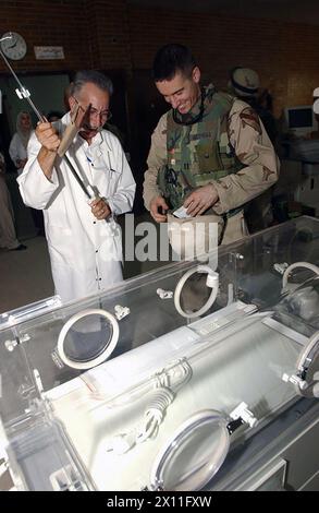 Cpt. David Mathias, the 2nd Battalion, 5th Cavalry Regiment (Task Force Lancer) battalion surgeon, helps Mahood Jasim, the Habi Bija Obstetrics-Gynecology and Pediatrics Hospital director, prepare a brand new incubator for service at in the hospital's post-natal care department ca. July 15, 2004 Stock Photo