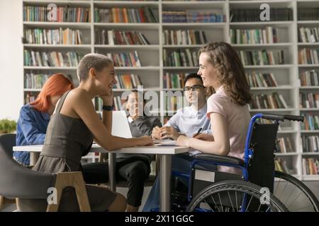 Group of students and girl with disability engaged in teamwork Stock Photo