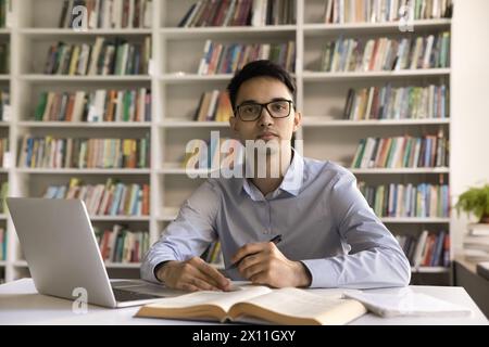 Serious Indian male student studying in library Stock Photo