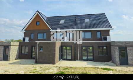 air source heat pump unit installed outdoors at a modern home with bricks in the Netherlands, warmte pomp translation air source heat pump  Stock Photo