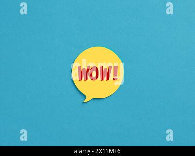 The word wow on yellow speech bubble over blue background. Stock Photo