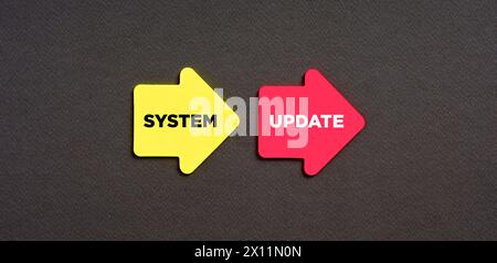 The word system update on arrow shaped stickers on blue background. Software update or operating system upgrade to keep the device up to date with add Stock Photo