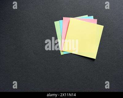 Blank or empty colorful adhesive note papers on black background. Stock Photo