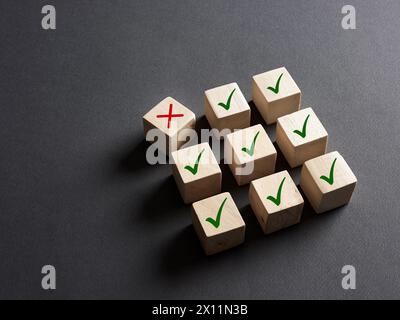 Choosing the wrong option, voting no or disapproval concept. Cross wrong symbol stands out from the check mark right symbols. Stock Photo