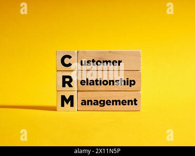 Wooden cubes with the the acronym CRM customer relationship management. Automation strategies for interacting with clients. Increase sales, optimize m Stock Photo