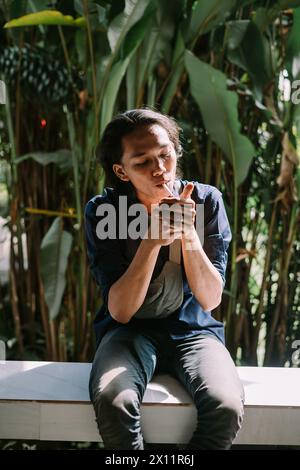 a man who was burning his cigarette in an area of dense trees Stock Photo
