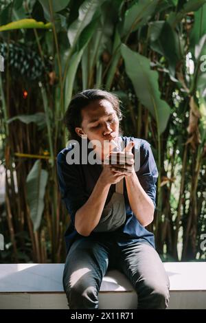 a man who was burning his cigarette in an area of dense trees Stock Photo