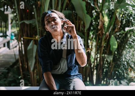 a man who was burning his cigarette in an area of dense trees Stock Photo