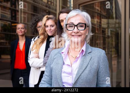 Team of multiracial diverse businesswomen led by boss smiling posing for camera Stock Photo