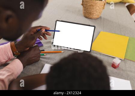 Father and son, both African American, focusing on tablet with copy space and doing homework Stock Photo
