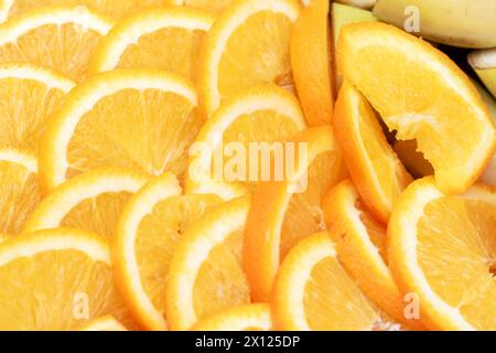 Assorted citrus fruit slices with a banana in the background Stock Photo