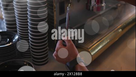 Image of spots of light over man making coffee working in cafe Stock Photo