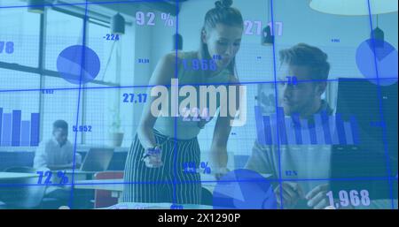 Image of changing numbers and graphs over diverse coworkers discussing reports on desk Stock Photo