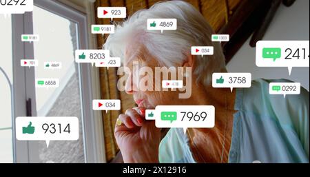Image of changing numbers, icons in notification bars, senior thoughtful caucasian woman Stock Photo