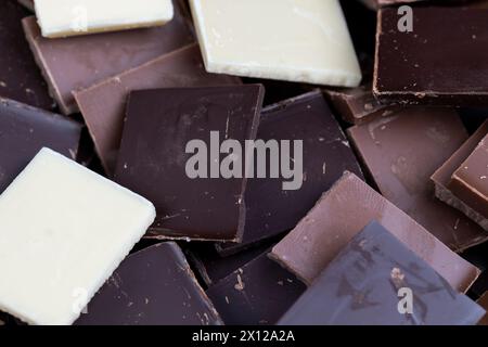 mixed together different types of chocolate, white, bitter and milk chocolate pieces Stock Photo