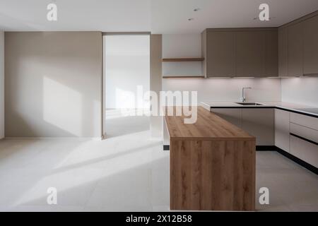 New kitchen that has never been used, a large wooden table in front that can be used for both cooking and eating.  Modern space, flat ready to rent in Stock Photo