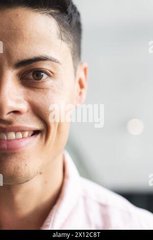 A young biracial man with brown eyes smiling in a modern business office with copy space Stock Photo