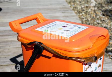 Jette, Brussels, Belgium, April 10, 2024 - Orange disposal container for organic waste recycling Stock Photo