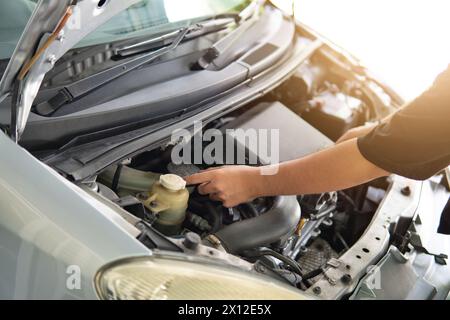 Close-up image of man inspecting and checking car engine. Transportation concept. Stock Photo