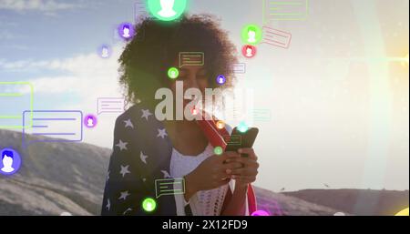 Image of media icons over happy biracial woman using smartphone Stock Photo