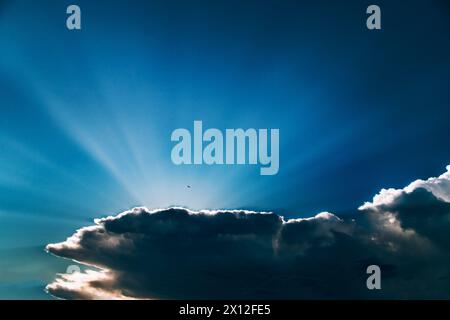 Dark cloud with majestic sun flare shining through Stock Photo
