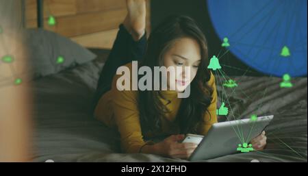 Image of media icons over happy caucasian woman using tablet Stock Photo