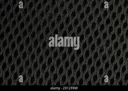 soft black ventilated mesh fabric with holes, black synthetic fabric for use in the manufacture of items Stock Photo