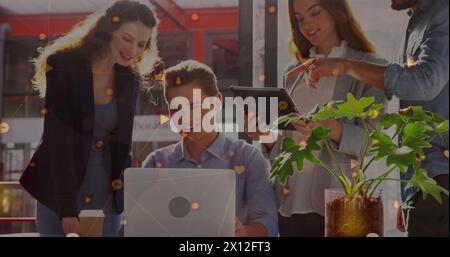 Network of digital icons over diverse male and female office colleagues using electronic devices Stock Photo