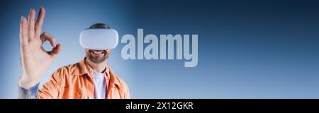 A man in an orange shirt, wearing a blindfold, poses in a studio setting with a virtual reality headset, exploring the metaverse. Stock Photo