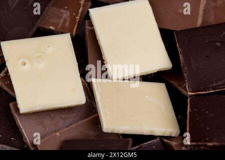 mixed together different types of chocolate, white, bitter and milk chocolate pieces Stock Photo