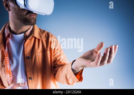 A man in a studio setting wearing a virtual reality glasses, exploring the Metaverse. Stock Photo